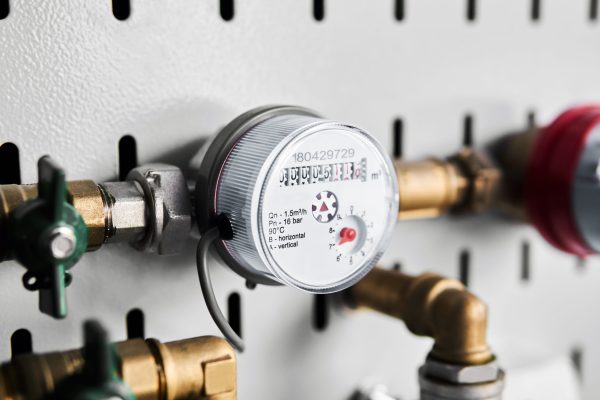 residential water meter installed on the pipeline and connected to remote reading device through cable